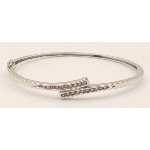 1388 - A 9K WHITE GOLD DIAMOND SET HINGED BANGLE WITH 2 SAFETY CATCHES .     7.7gms