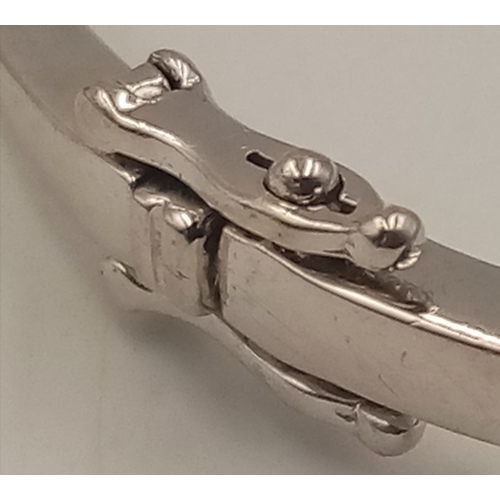 1388 - A 9K WHITE GOLD DIAMOND SET HINGED BANGLE WITH 2 SAFETY CATCHES .     7.7gms