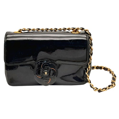 622 - A Chanel Camellia Flap Bag in Black Patent Leather. Exterior open pocket. Gold tone hardware. Classi... 