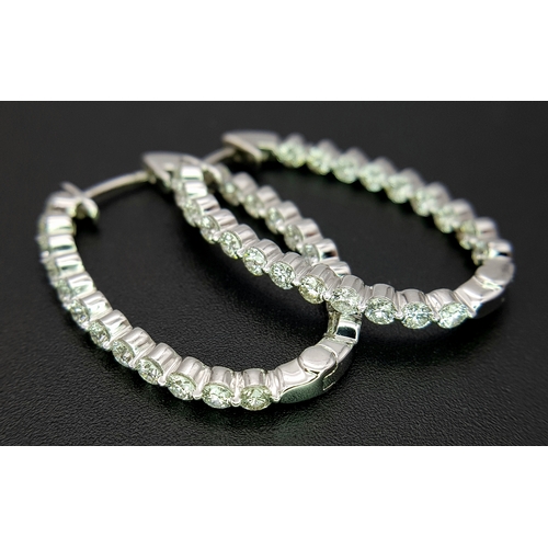 1009 - A Pair of 18K White Gold and Diamond Elongated Hoop Earrings. 2.2ctw of round brilliant cut diamonds... 