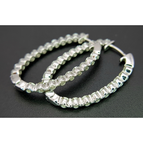 1009 - A Pair of 18K White Gold and Diamond Elongated Hoop Earrings. 2.2ctw of round brilliant cut diamonds... 