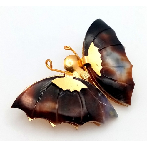 1093 - A vintage gilded butterfly brooch with tortoise shell wings. Total length 5cm.