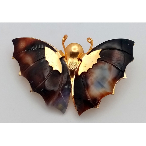 1093 - A vintage gilded butterfly brooch with tortoise shell wings. Total length 5cm.