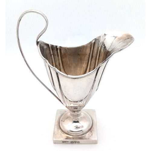 33 - A 1731 GEORGIAN SILVER ANTIQUE HELMET SHAPED CREAM JUG .        51gms    11.5cms