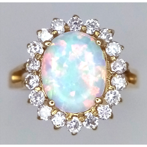 34 - A 14K YELLOW GOLD RING WITH LARGE CENTRAL FIRE OPAL SURROUNDED WITH A HALO OF WHITE SAPPHIRES .  4.2... 