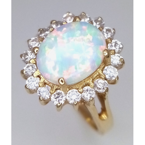 34 - A 14K YELLOW GOLD RING WITH LARGE CENTRAL FIRE OPAL SURROUNDED WITH A HALO OF WHITE SAPPHIRES .  4.2... 
