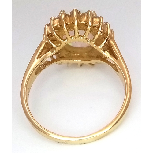 34 - A 14K YELLOW GOLD RING WITH LARGE CENTRAL FIRE OPAL SURROUNDED WITH A HALO OF WHITE SAPPHIRES .  4.2... 