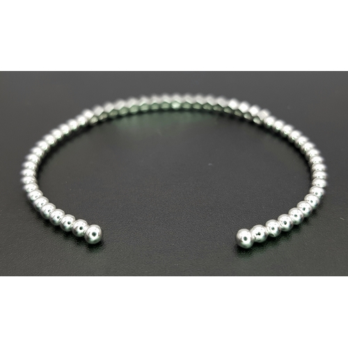 38 - A 14K WHITE GOLD BRACELET BANGLE. SET WITH SEVENTEEN 0.87CT ROUND BRILLIANT CUT NATURAL DIAMONDS. H/... 