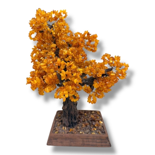 1106 - An Amber Gemstone Tree Sculpture.
Amber stone chip foliage arranged as a stylized tree on a carved w... 