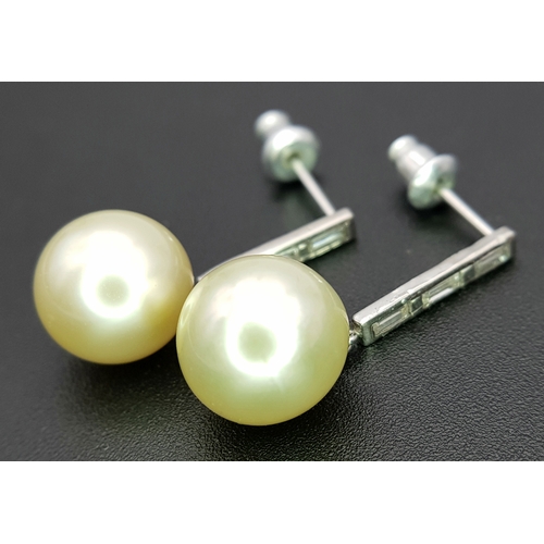 1063 - A Pair of 18K White Gold (tests as) Diamond and South Sea Pearl Drop Earrings. 11mm pearls. Baguette... 