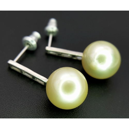 1063 - A Pair of 18K White Gold (tests as) Diamond and South Sea Pearl Drop Earrings. 11mm pearls. Baguette... 