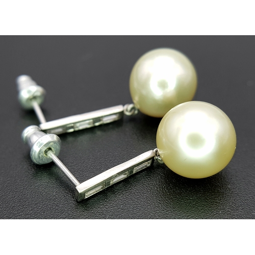 1063 - A Pair of 18K White Gold (tests as) Diamond and South Sea Pearl Drop Earrings. 11mm pearls. Baguette... 