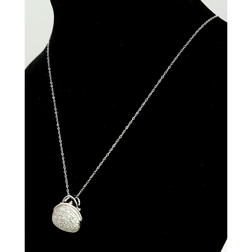 1070 - A 14K White Gold and Diamond Handbag Pendant on a 9K White Gold Chain. 18mm and 44cm. 3.4g. Ref: 6.3