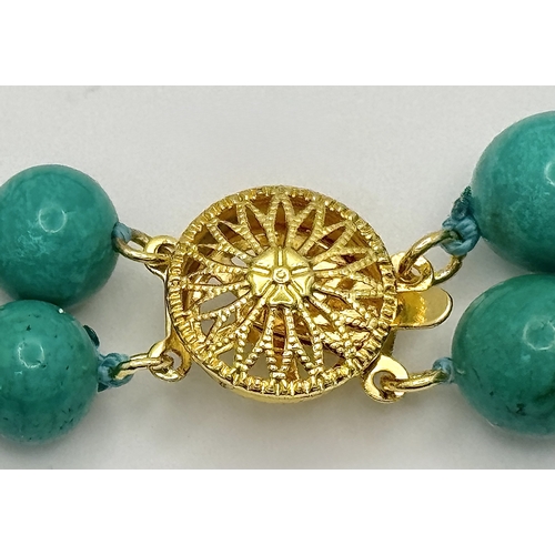 1112 - A Two Row Turquoise Beaded Necklace. Gilded spacers and clasp. 8mm beads. 42-46cm necklace length.