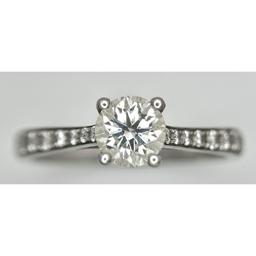 12 - A 950 Platinum and Diamond Ring. A 0.45ct round brilliant cut diamond with diamond accents on should... 