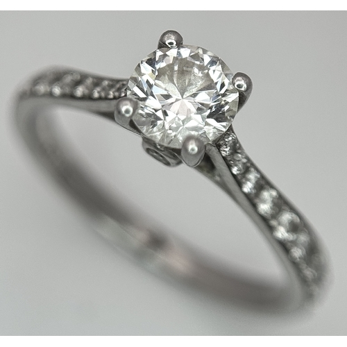 12 - A 950 Platinum and Diamond Ring. A 0.45ct round brilliant cut diamond with diamond accents on should... 