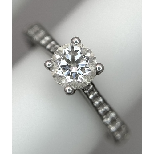 12 - A 950 Platinum and Diamond Ring. A 0.45ct round brilliant cut diamond with diamond accents on should... 