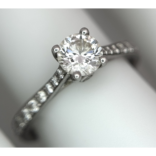 12 - A 950 Platinum and Diamond Ring. A 0.45ct round brilliant cut diamond with diamond accents on should... 