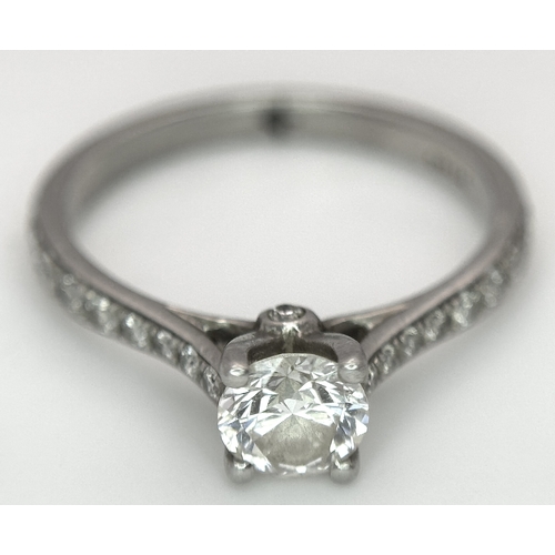 12 - A 950 Platinum and Diamond Ring. A 0.45ct round brilliant cut diamond with diamond accents on should... 