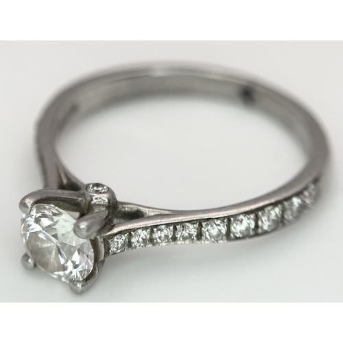 12 - A 950 Platinum and Diamond Ring. A 0.45ct round brilliant cut diamond with diamond accents on should... 