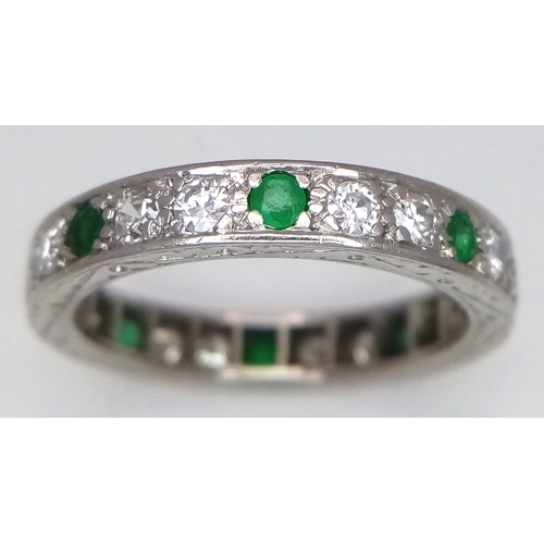 31 - AN 18K WHITE GOLD, DIAMOND AND EMERALD SET, FULL ETERNITY RING. 0.50 TCW, 4.7G, SIZE O. SC 4049