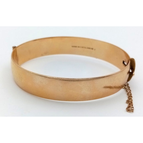 43 - A Vintage 9K Gold (Metal Core) Bangle. 13mm width. Clip open design. Safety chain. 27.5g total weigh... 