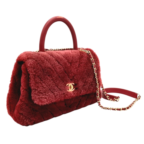 54 - A Chanel Burgundy Shearling Coco Top Handle Bag. Burgundy textile exterior with gold tone hardware, ... 