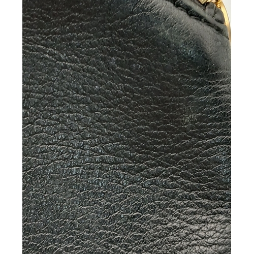 530 - A Christian Dior Black Leather Cosmetic Pouch. Black leather exterior with gold-tone hardware and to... 