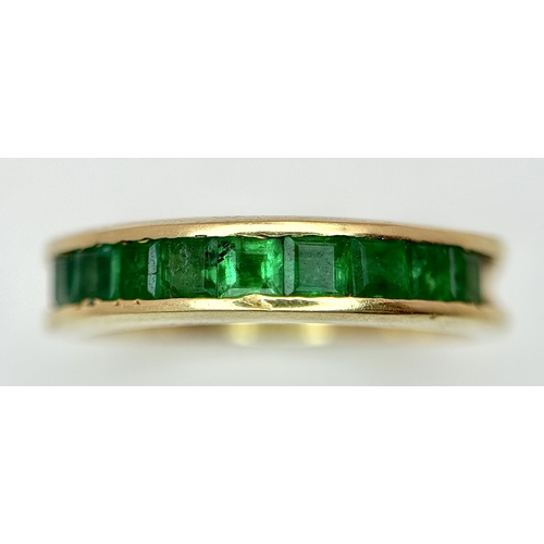 548 - An 18K Yellow Gold Channel Set Emerald Ring. Size O. Nine square shaped emeralds. 5.8g. N10/24756.