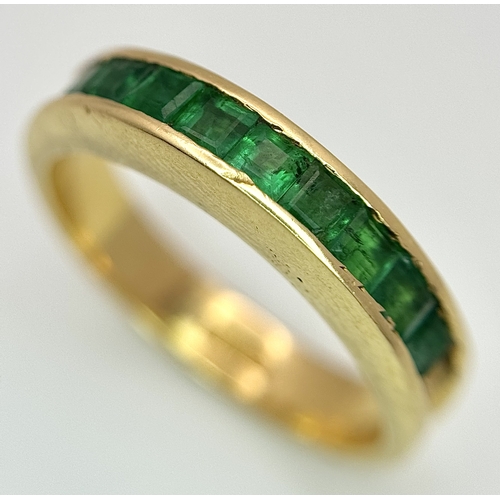 548 - An 18K Yellow Gold Channel Set Emerald Ring. Size O. Nine square shaped emeralds. 5.8g. N10/24756.