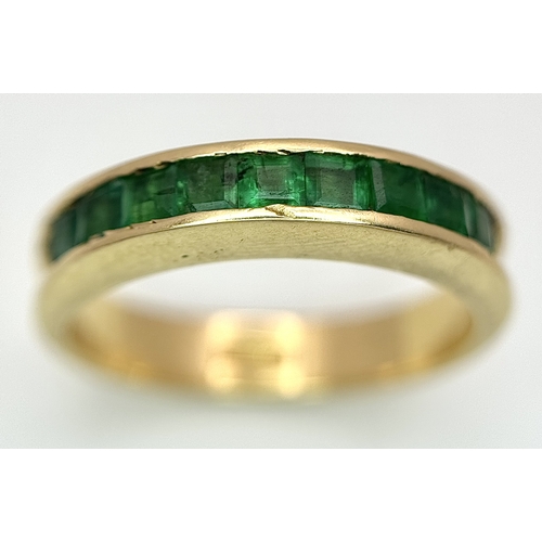 548 - An 18K Yellow Gold Channel Set Emerald Ring. Size O. Nine square shaped emeralds. 5.8g. N10/24756.