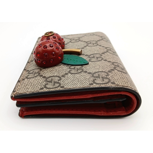 549 - A Gucci GG Supreme Cherry Card Holder Wallet. Ebony GG Supreme canvas exterior with gold-tone hardwa... 