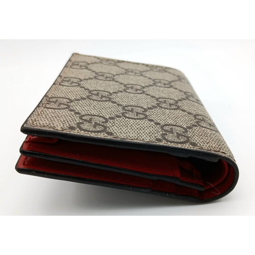 549 - A Gucci GG Supreme Cherry Card Holder Wallet. Ebony GG Supreme canvas exterior with gold-tone hardwa... 