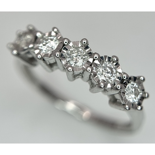 1012 - A 9K White Gold Five Stone Diamond Ring. Size O. 2.7g. NL16/11206.