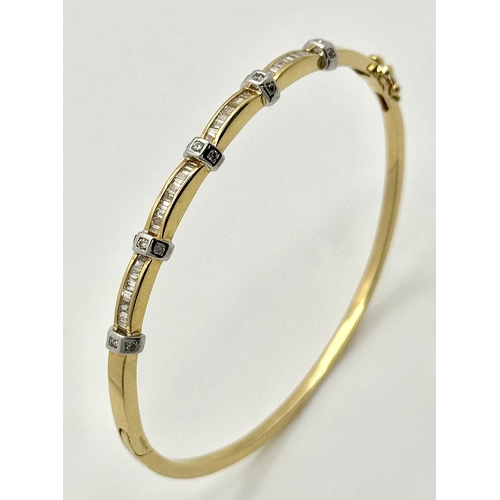 65 - An 18K Yellow Gold and Diamond Bangle. 1ctw of tapered baguette and round brilliant cut diamonds. Cl... 