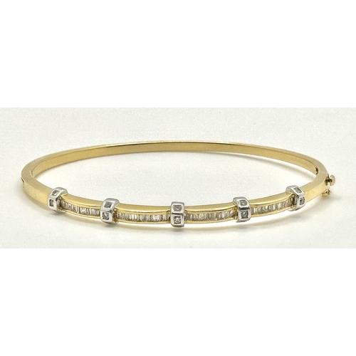 65 - An 18K Yellow Gold and Diamond Bangle. 1ctw of tapered baguette and round brilliant cut diamonds. Cl... 