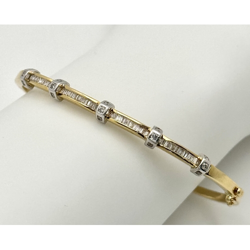 65 - An 18K Yellow Gold and Diamond Bangle. 1ctw of tapered baguette and round brilliant cut diamonds. Cl... 