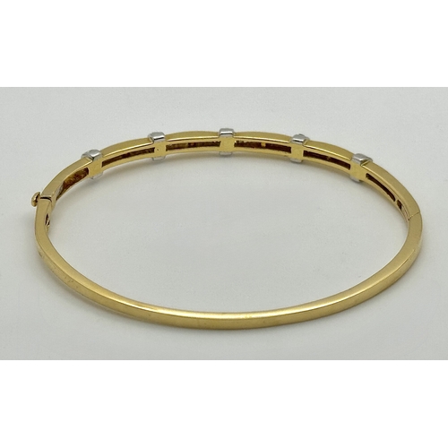 65 - An 18K Yellow Gold and Diamond Bangle. 1ctw of tapered baguette and round brilliant cut diamonds. Cl... 