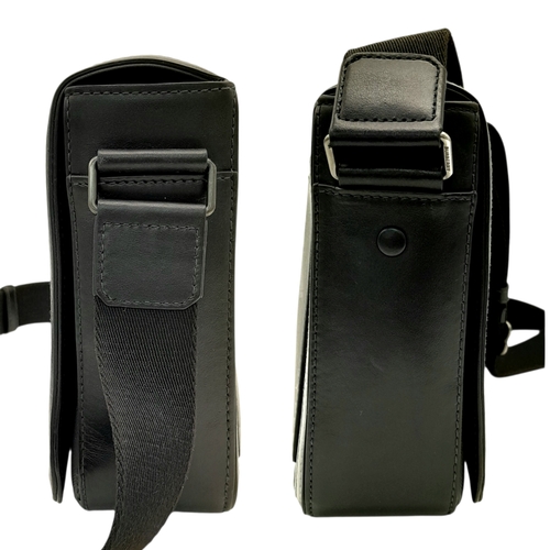 96 - A Burberry Black London Check Crossbody Bag. Black coated canvas exterior with silver-toned hardware... 