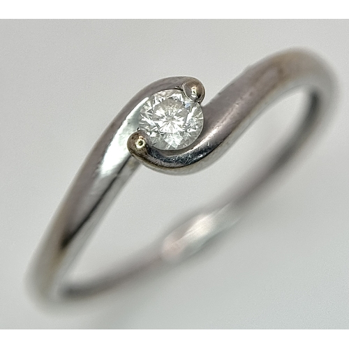 106 - An 18K White Gold Diamond Crossover Solitaire Ring. Size M. Brilliant round cut diamond c. 0.10ct. 1... 