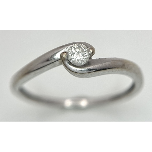 106 - An 18K White Gold Diamond Crossover Solitaire Ring. Size M. Brilliant round cut diamond c. 0.10ct. 1... 