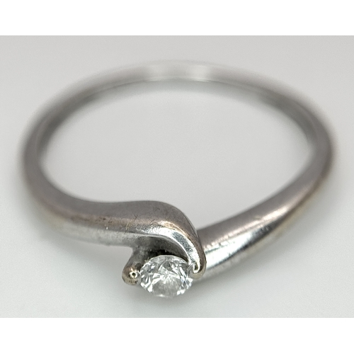 106 - An 18K White Gold Diamond Crossover Solitaire Ring. Size M. Brilliant round cut diamond c. 0.10ct. 1... 