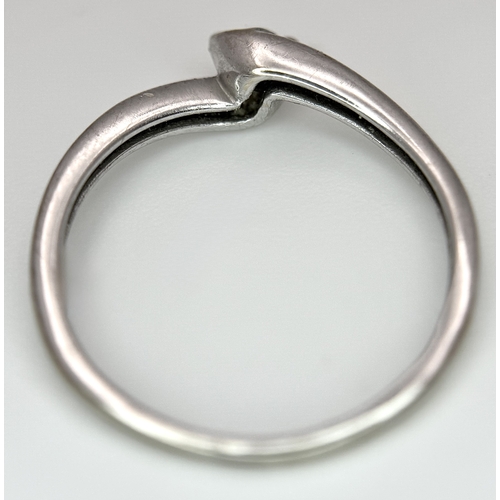 106 - An 18K White Gold Diamond Crossover Solitaire Ring. Size M. Brilliant round cut diamond c. 0.10ct. 1... 