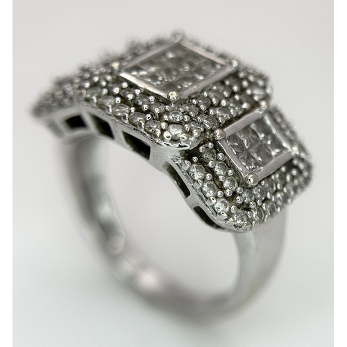 130 - An 18K White Gold Diamond Dress Ring. An array of pave round and princess cut diamonds c. 1.2ctw. Si... 