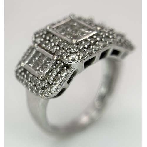 130 - An 18K White Gold Diamond Dress Ring. An array of pave round and princess cut diamonds c. 1.2ctw. Si... 