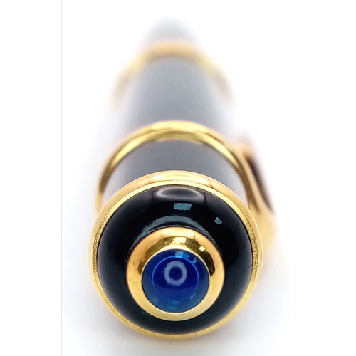 1052 - A Stylish Cartier Diabolo Black and Gold, Blue Sapphire Cabochon Ballpoint Pen, 13.7cm Length.