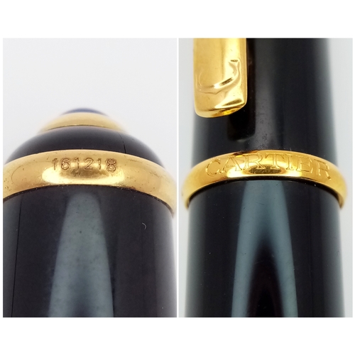 1052 - A Stylish Cartier Diabolo Black and Gold, Blue Sapphire Cabochon Ballpoint Pen, 13.7cm Length.
