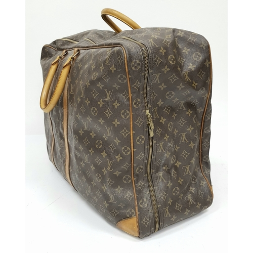 144 - A Louis Vuitton Brown Monogram Keepall Travel Bag. Brown monogram coated canvas exterior with gold-t... 