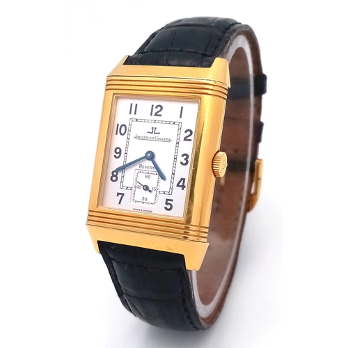 AN 18K YELLOW GOLD JAEGER-LE-COULTRE, REVERSO GENTS MECHANICAL WATCH. MODEL 270.1.62. BLACK LEATHER STRAP WITH 18K GOLD BUCKLE. 18K GOLD CASE - 27 X 43MM. WHITE AND GREY DIAL WITH SECOND SUB DIAL. IN WORKING ORDER. HAND-WIND. COMES WITH A WATCH REGISTER REPORT. PN-8279. 77G TOTAL WEIGHT.