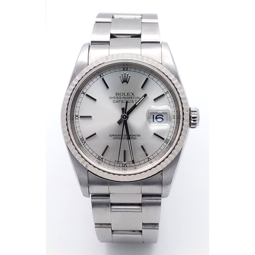 A Classic 1990s Rolex Datejust Automatic Gents Watch. Stainless steel bracelet and case - 36mm. Silver tone dial with date window. In working order. Comes with a Watch Register Report. PN-8303-2.